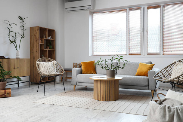 Стильный интерьер гостиной с бамбуковыми стеблями на кофейном столике и диване - Фото, изображение