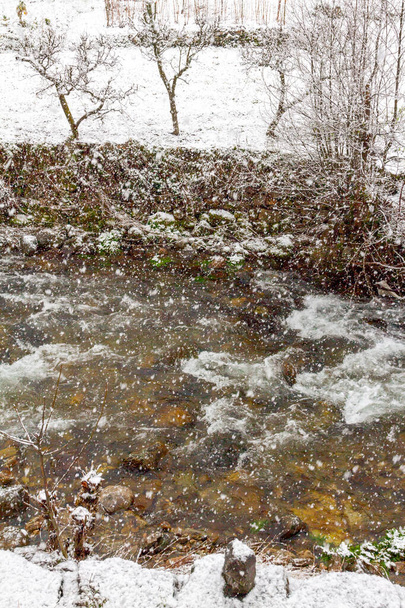 zasněžená řeka v krásném horském městečku - Fotografie, Obrázek