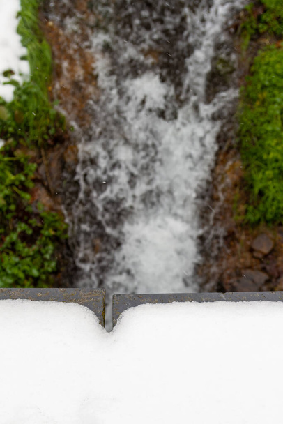 Wasserfall im Wald einer malerischen verschneiten Stadt in der spanischen Provinz Len, genannt Colinas del Campo - Foto, Bild
