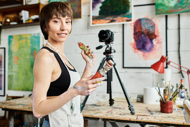 Une femme tenant élégamment de la peinture dans sa main. - Photo, image