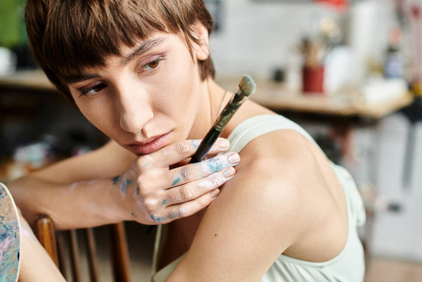 Aantrekkelijke vrouw zittend met een penseel. - Foto, afbeelding