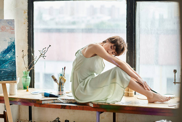 Una mujer sofisticada se sienta frente a una ventana con vistas al aire libre. - Foto, imagen