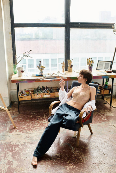 Nainen istuu tuolilla taidestudiossa. - Valokuva, kuva