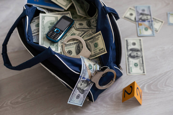 Schwarzer Duffelsack voller Dollarnoten im Kriminalkommissariat, Konzeptbild. Hochwertiges Foto - Foto, Bild
