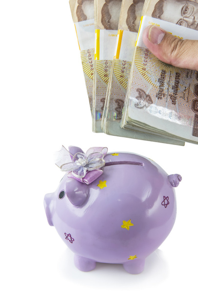 Sparen, männliche Hand legt ein Geld in Sparschwein isoliert auf weißem Hintergrund. - Foto, Bild