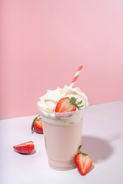 batido de fresa o batido, cóctel de frutas de verano con fresas frescas, sobre fondo rosa blanco, pancarta de menú de bar o fondo, bebidas de café maqueta - Foto, imagen