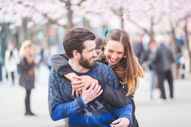Feliz pareja hipster en Estocolmo con flores de cerezo
 - Foto, imagen
