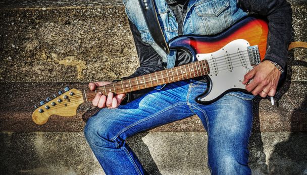 κιθαρίστας με ένα πολύχρωμο κιθάρα στο hdr - Φωτογραφία, εικόνα