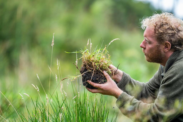 étudiant en sciences du sol agriculture regardant un échantillon de sol. fille sur une ferme regardant les racines des plantes en Australie - Photo, image