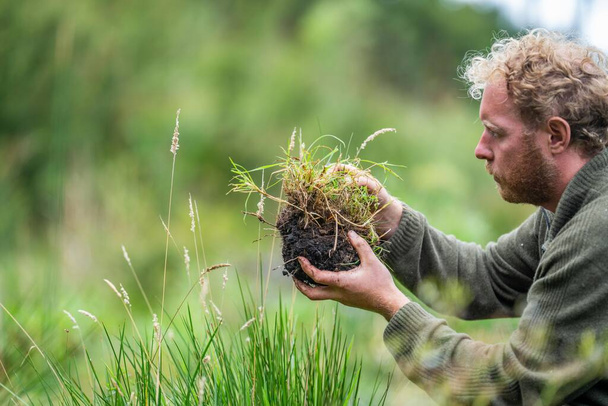 agriculteur Tenant le sol dans une main, se sentant compost dans un champ en Tasmanie Australie. spécialiste des sols en Australie - Photo, image