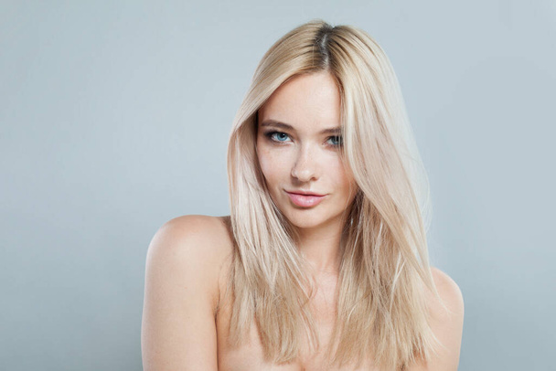 Joyful young blonde lady with fresh clear skin and long smooth straight hairstile on white background - Photo, Image
