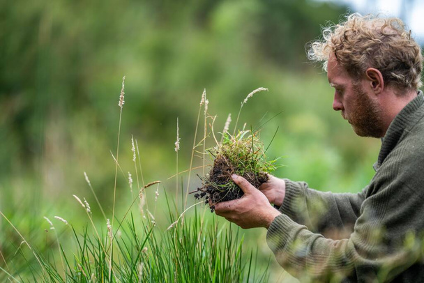 agriculteur Tenant le sol dans une main, se sentant compost dans un champ en Tasmanie Australie. spécialiste des sols en Australie - Photo, image