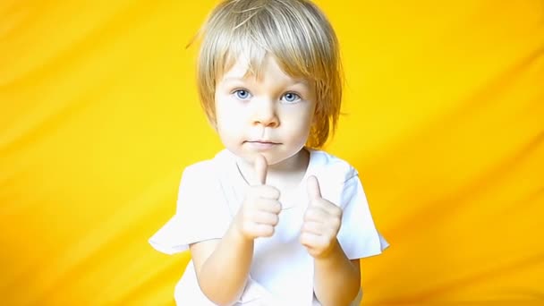 Okay. Happy baby child looking approvingly at camera showing ok gesture, like sign positive feedback, approve something good, celebrate victory. Kid on yellow background. High quality 4k footage. - Footage, Video