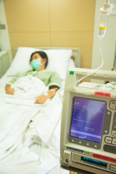 Внутривенные IV капельные насосы в больничной палате с пациентом - в наличии
 - Фото, изображение