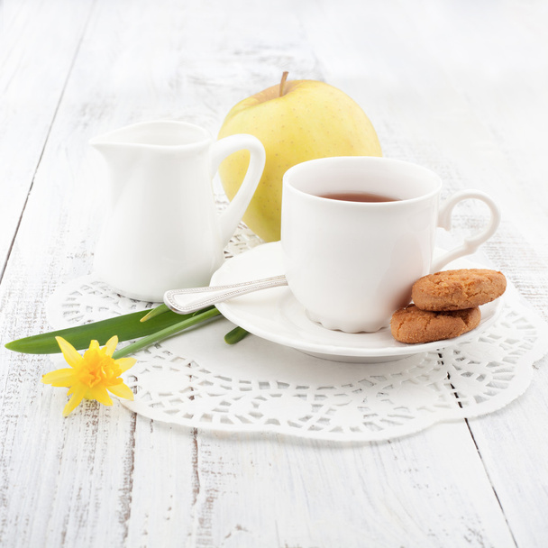 Aamiainen kotitekoisia evästeitä ja omenaa, kupin teetä
 - Valokuva, kuva