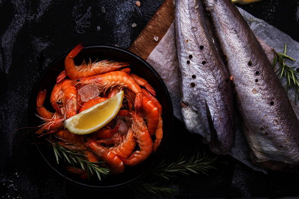 Surtido de mariscos crudos, langostinos y pescados de merluza con limón y hierbas para platos visuales de menú de restaurante - Foto, imagen