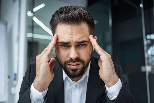 turhautunut liikemies, joka kärsii päänsärystä migreeni työpaikalla, hierovat temppeleitä, väsymyksen tunne uupunut, krooninen työstressi - Valokuva, kuva