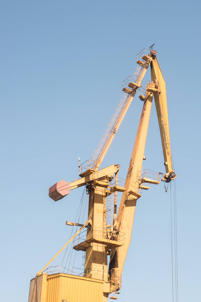 明るい晴れた日の荷を下す川砂の港の産業クレーン - 写真・画像
