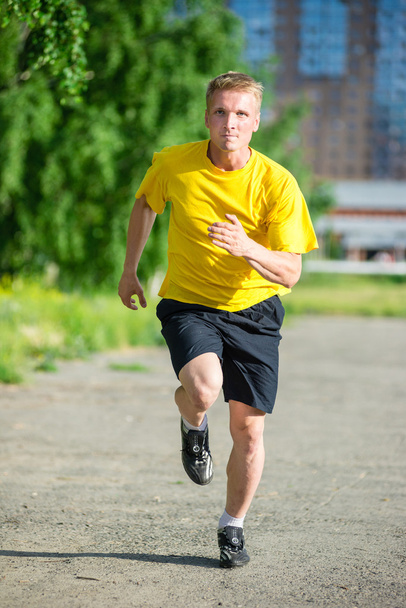 Sportowy człowiek jogging w parku ulicy. Outdoor fitness. - Zdjęcie, obraz
