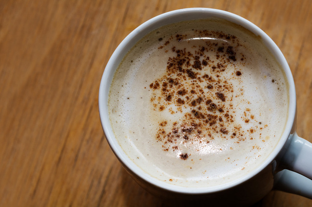 Kaffee mit Milchschaum und Kakao auf einem Holztisch, Kopierraum - Foto, Bild