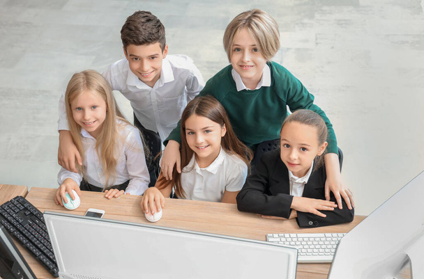 Niños pequeños estudiando en el laboratorio de computación escolar - Foto, imagen