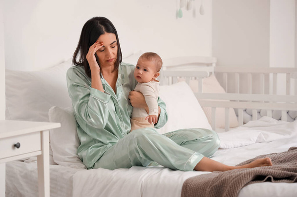 Triste jeune femme avec son bébé souffrant de dépression postnatale dans la chambre - Photo, image