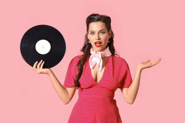 Retrato de mulher pin-up surpreso com disco de vinil no fundo rosa - Foto, Imagem