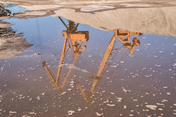 Портовые промышленные краны при выгрузке речного песка в ясный солнечный день - Фото, изображение