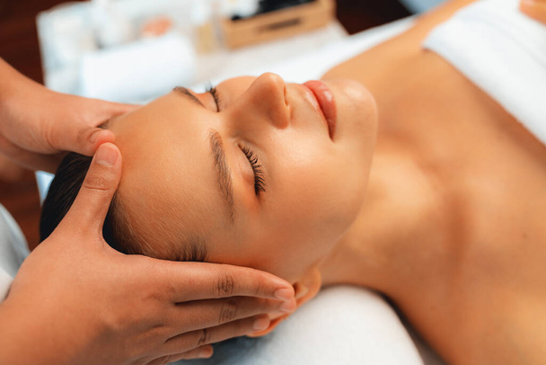 Donna caucasica godendo rilassante anti-stress massaggio alla testa e coccole bellezza del viso svago della pelle in dayspa luce moderna ambiente al resort di lusso o salone spa dell'hotel. Silenzioso - Foto, immagini