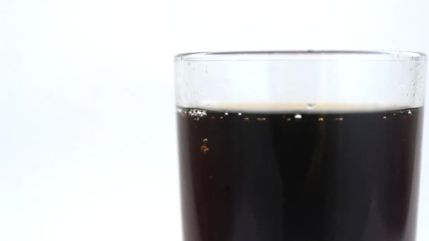 Een koolzuurhoudende drank (cokes of pespi) wordt in een glas gegoten - Video