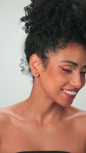 Professionele make-up master brengt verf aan op een jong model met krullend haar. verticaal, trage beweging, close up. - Video