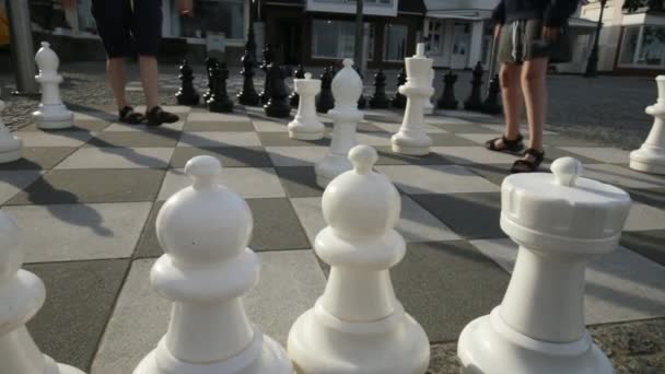 Sokak satrancı. İnsanlar sokakta satranç tahtasının üzerinde büyük satranç taşlarıyla oynuyor. 4k görüntü - Video, Çekim