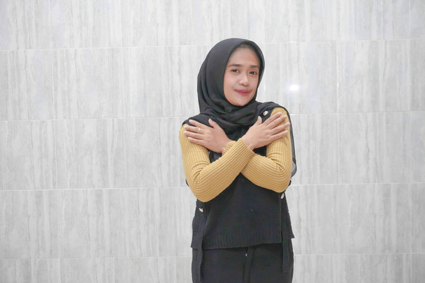Expression d'une Indonésienne asiatique portant un hijab noir à manches jaunes - Photo, image