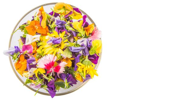 Mélanger la salade de fleurs comestibles dans un bol en verre sur fond blanc
 - Photo, image