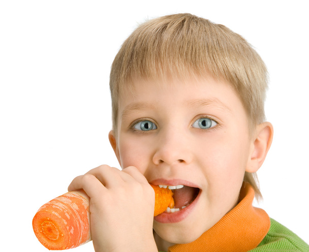 Happy little boy biting a carrot - Foto, Bild