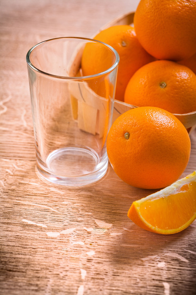 Oranges in bucket on wooden table - Фото, изображение