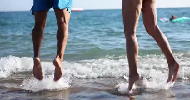 Kobieta i mężczyzna skaczą po plaży morskiej. miesiąc miodowy i szczęśliwy turysta na wakacjach - Materiał filmowy, wideo