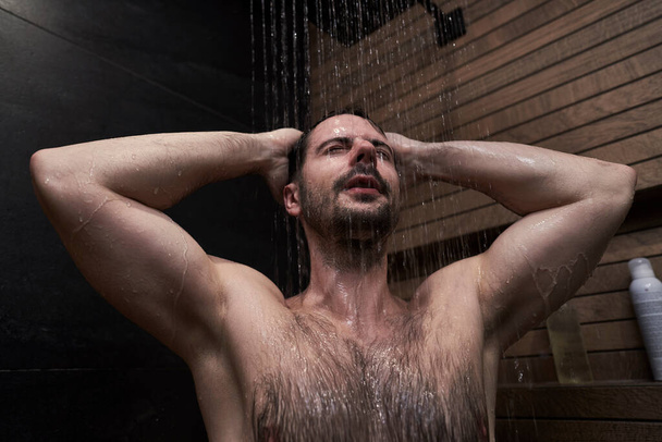 Caucasian man taking shower at home - Foto, Imagem
