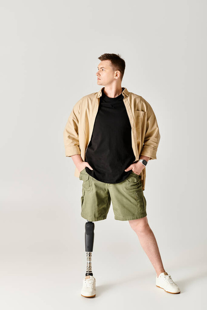 Un bell'uomo con una gamba protesica posa in una posizione attiva e aggraziata. - Foto, immagini