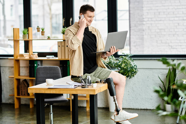 Красивий бізнесмен з протезною ногою працює за столом за допомогою ноутбука. - Фото, зображення