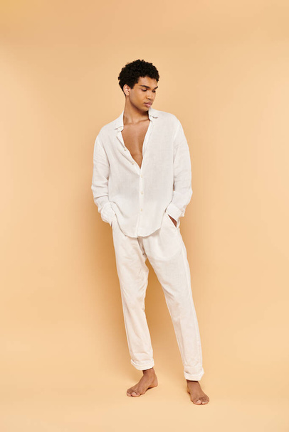 tyylikäs tyylikäs tyylikäs afrikkalainen amerikkalainen mies tyylikäs valkoinen vaatteet katselee pois beige taustalla - Valokuva, kuva