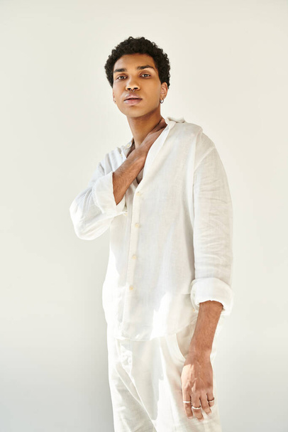 well dressed young african american man in white attire and looking at camera on beige backdrop - Photo, Image