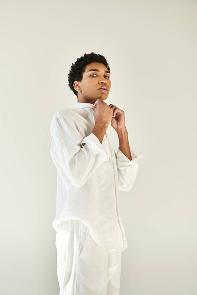 elegante atraente homem afro-americano em roupa aconchegante posando no fundo bege e olhando para a câmera - Foto, Imagem