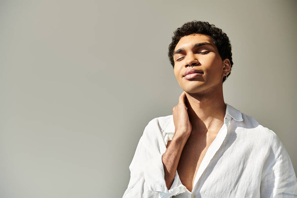 verleidelijk Afrikaans amerikaans mannelijk model in linnen verfijnde kleding poseren op beige achtergrond - Foto, afbeelding