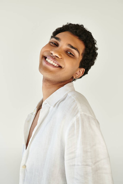 alegre sofisticado afroamericano hombre en ropa de lino sonriendo a la cámara sobre fondo beige - Foto, Imagen