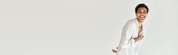 vesele svůdný africký americký mužský model v plátně odvracející pohled na béžové pozadí, banner - Fotografie, Obrázek