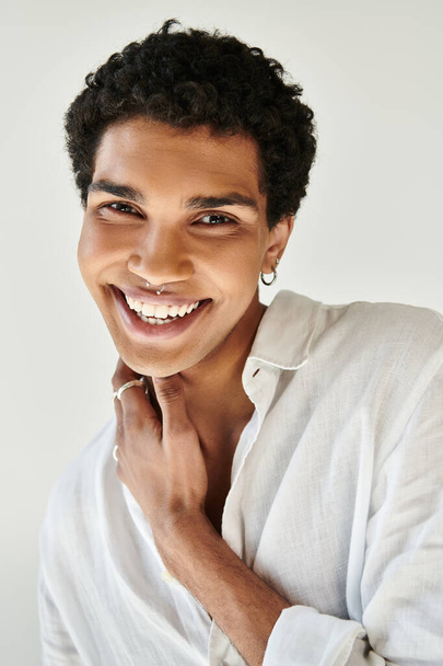 ベージュの背景でカメラで笑顔のリネン服のメリーファッショナブルなアフリカ系アメリカ人男性 - 写真・画像