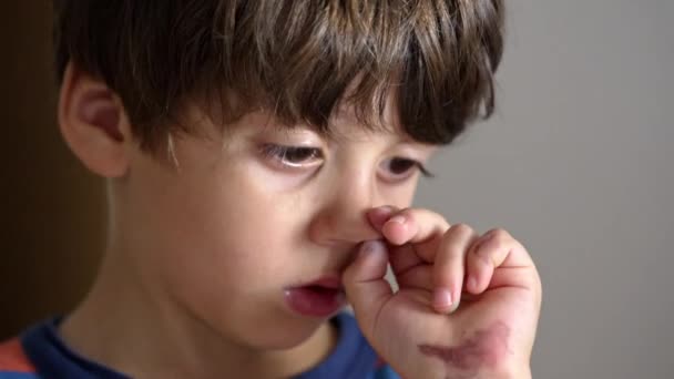 Kleiner Junge zerkratzt Nase beim Malen mit lackierten Händen - Filmmaterial, Video