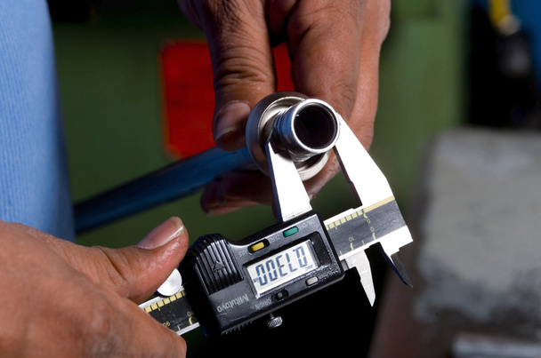 calibrador que mide una barra de hierro
 - Foto, Imagen