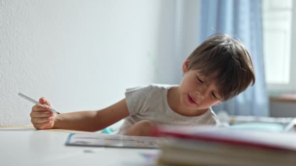 Chlapec vyjadřuje radost z učení, zpěvu a tance během domácího úkolu - Záběry, video
